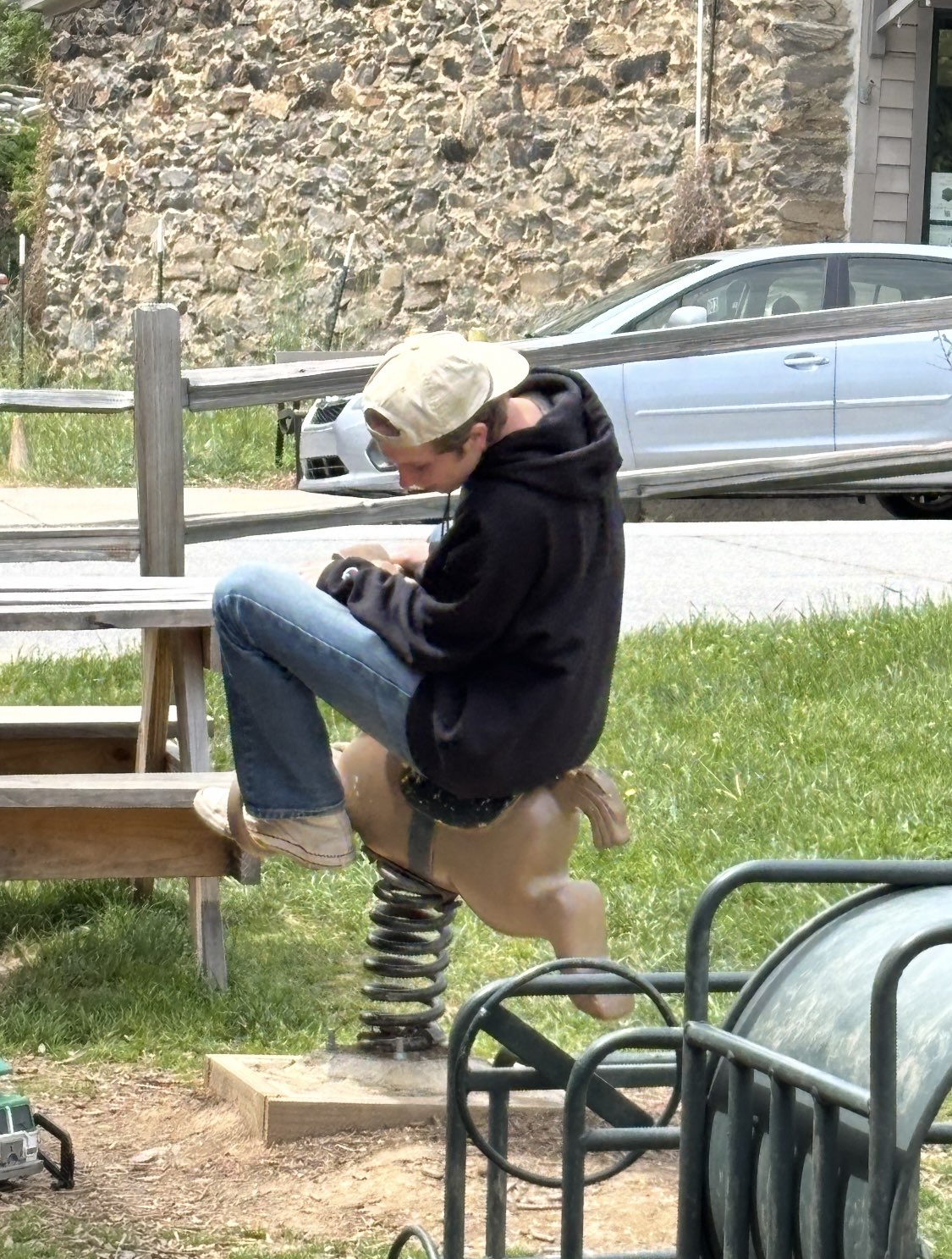 Ryder Mann riding a spring horse at a playground