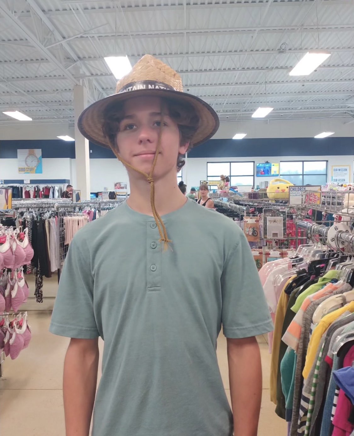 Ryder Mann in a straw hat at a thrift store