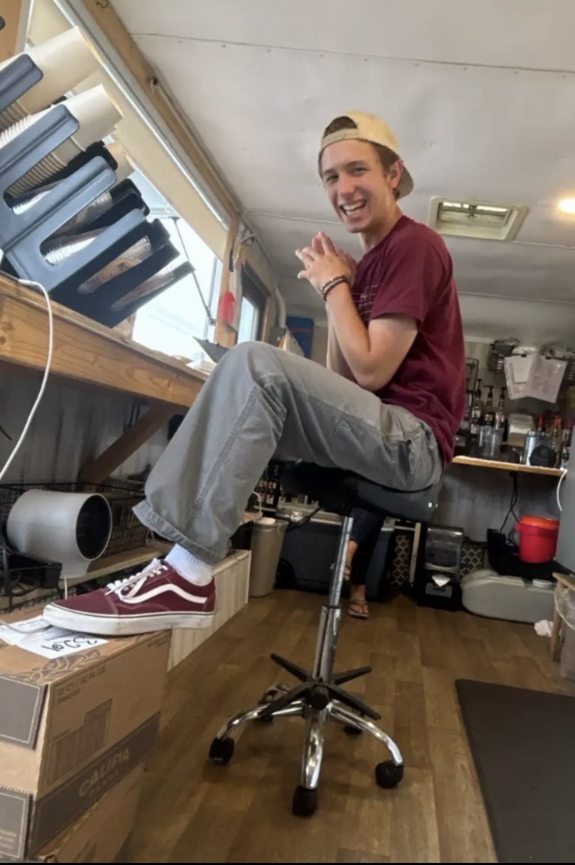 Ryder Mann seated on a rolling stool in a coffee truck